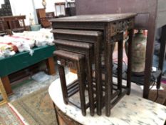 AN ORIENTAL NEST OF FOUR CARVED TABLES.