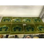 EIGHT ART NOUVEAU OLIVE GREEN GROUND TILES, EACH WITH FIVE BLUE BUDS