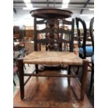 AN ARTS AND CRAFTS STAINED WOOD LOW CHAIR, THE THREE BARS TO THE BACK CENTRALLY PIERCED ABOVE A RUSH