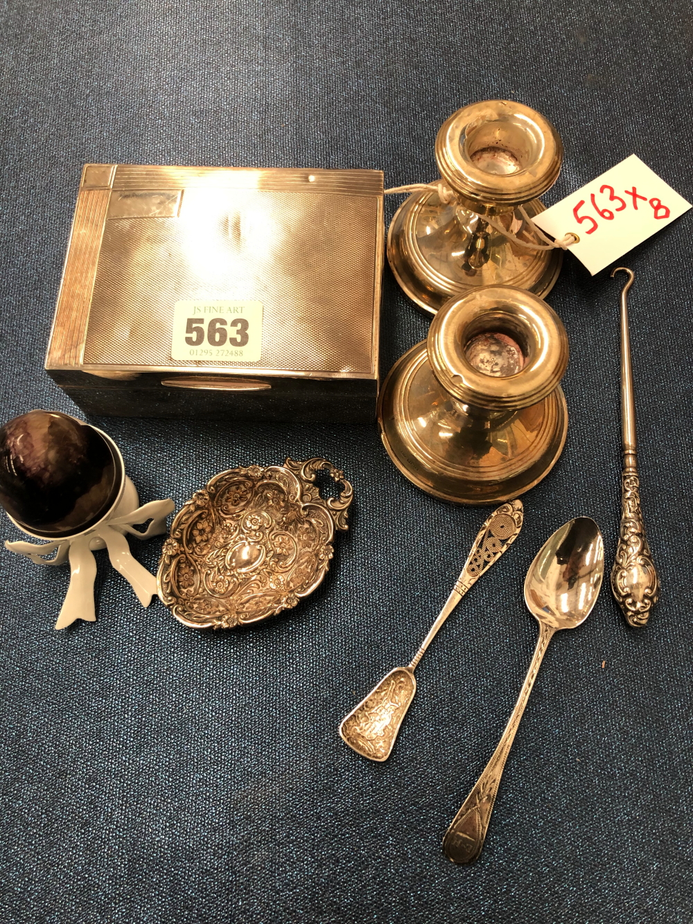 A PAIR OF SILVER DWARF CANDLESTICKS, A SILVER CIGARETTE BOX, A SWEETMEAT DISH, TWO TEA SPOONS, A