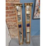 A PAIR OF SLENDER RECTANGULAR MIRRORS WITHIN GILT RIBBON BOUND REEDED COLUMN SIDES. 113 x 18.5cms.