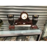 A FRENCH MANTEL CLOCK STRIKING ON A COILED ROD AND RETAILED BY BENSONS WITHIN A RED PUDDING STONE