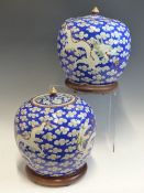 A PAIR OF CHINESE JARS PAINTED WITH MIRROR IMAGES OF DRAGONS AMONGST CLOUDS ON A BLUE GROUND. H