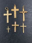 A GROUP OF SIX 9ct GOLD HALLMARKED OR 9ct STAMPED CROSS AND CRUCIFIX PENDANTS. LARGEST 3.3cms,