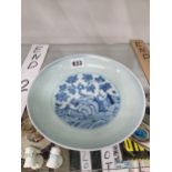 A CHINESE BLUE AND WHITE PLATE DECORATED WITH A FENCED TREE
