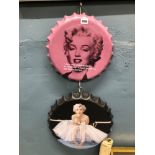 TWO MARILYN MONROE DECORATED OVERSIZE BOTTLE CAPS.