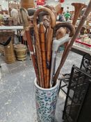 A QUANTITY OF WALKING STICKS IN A POTTERY STICK STAND