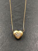 A HALLMARKED 9ct GOLD STONE SET 3D HEART PENDANT SUSPENDED ON A 9ct GOLD SNAKE CHAIN. LENGTH