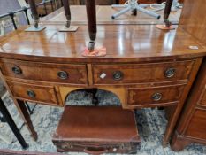 AN ANTIQUE MAHOGANY BOW FRONT FOUR DRAWER DRESSING TABLE.