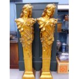 A PAIR OF ART NOUVEAU TASTE GILT BUSTS OF LADIES DECORATED WITH FLOWERS AND RAISED ON TAPERING