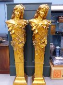 A PAIR OF ART NOUVEAU TASTE GILT BUSTS OF LADIES DECORATED WITH FLOWERS AND RAISED ON TAPERING