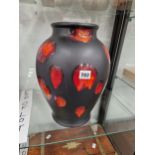 A POOLE POTTERY RED SPLASHED BLACK GROUND VASE