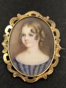 A PAINTED PORTRAIT MINIATURE BROOCH WITH A GLAZED BACK PANEL ENCLOSING WOVEN HAIR. MEASUREMENTS 6