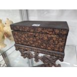 A MINIATURE INDIAN BLACK LACQUER CASKET ON STAND GILT WITH FLOWERS