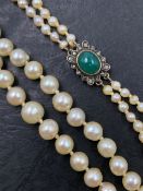 A VINTAGE DOUBLE ROW OF GRADUATED PEARLS. THE NECKLACE COMPLETED WITH A GREEN CABOCHON AND OLD CUT