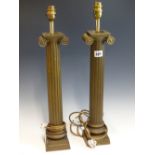 A PAIR OF SIMULATED BRONZE TABLE LAMPS, THE REEDED COLUMNS WITH IONIC CAPITALS. H 56cms.