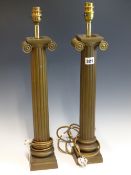 A PAIR OF SIMULATED BRONZE TABLE LAMPS, THE REEDED COLUMNS WITH IONIC CAPITALS. H 56cms.