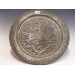 AN ISLAMIC TIN DISH WORKED IN RELIEF WITH AN EQUESTRIAN BOWMAN HUNTING DEER. Dia. 40cms.