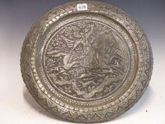 AN ISLAMIC TIN DISH WORKED IN RELIEF WITH AN EQUESTRIAN BOWMAN HUNTING DEER. Dia. 40cms.