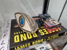 A BOOK OF JAMES BOND POSTERS, FOUR PACKS OF PLAYING CARDS AND A TROIKA TYPE POTTERY MODEL EYE