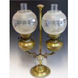 A PAIR OF BRASS OIL LAMPS WITH FROSTED GLASS SHADES, ADJUSTABLE ON A BRASS COLUMN WITH A STEPPED