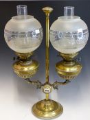 A PAIR OF BRASS OIL LAMPS WITH FROSTED GLASS SHADES, ADJUSTABLE ON A BRASS COLUMN WITH A STEPPED