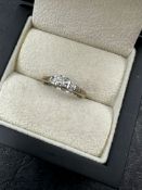 AN 18ct WHITE GOLD HALLMARKED DIAMOND RING WITH TAPERED BAGUETTE DIAMOND SHOULDERS. TOTAL