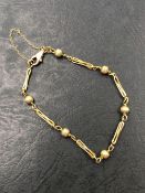 A 9ct HALLMARKED BEAD AND TWISTED BAR LINK BRACELET, COMPLETE WITH SAFETY CHAIN. WEIGHT 5.51grms.