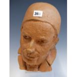 A SCULPTED TERRACOTTA HEAD OF A MOUSTACHIOED MAN WEARING A SKULL CAP. H 26cms.