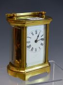 A LEATHER CASED FRENCH CARRIAGE TIMEPIECE, THE NARROW SIDES OF THE BEVELLED GLASS CASE BOWED