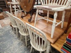 A LARGE PAINTED HARDWOOD DINING TABLE AND FIVE SIMILAR SPINDLE BACK CHAIRS.