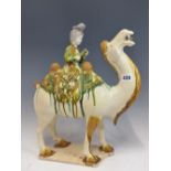 A TANG STYLE CAMEL RIDDEN BY A LADY PLAYING A FLUTE. H 41cms.