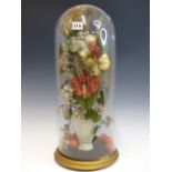 A PARIAN VASE FULL OF SILK FLOWERS WITH ORANGES AT ITS FOOT AND UNDER A GLASS DOME. H 52cms.