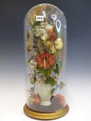 A PARIAN VASE FULL OF SILK FLOWERS WITH ORANGES AT ITS FOOT AND UNDER A GLASS DOME. H 52cms.