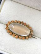 AN ANTIQUE CORAL AND CABOCHON GEMSET OVAL BROOCH. THE BROOCH UNHALLMARKED, ASSESSED AS 10ct GOLD.
