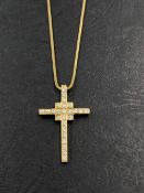 A STONE SET CROSS PENDANT SUSPENDED ON A SNAKE CHAIN. THE PENDANT AND CHAIN BOTH UNHALLMARKED, THE