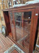 AN ANTIQUE MAHOGANY BOOKCASE WITH SLIDING DOORS AND ADJUSTABLE SHELVES.