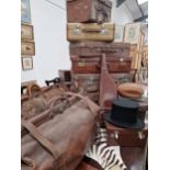 A GOOD COLLECTION OF ANTIQUE LEATHER LUGGAGE TOGETHER WITH A GUN CASE, A TOP HAT AND A RUBY BALL.
