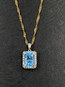 A DIAMOND AND BLUE TOPAZ PENDANT SUSPENDED ON A 9ct HALLMARKED GOLD SINGAPORE CHAIN. THE PENDANT