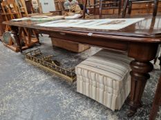 A LARGE LATE VICTORIAN OAK EXTENDING DINING TABLE WITH THREE LEAVES.