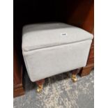A MODERN BOX STOOL ON CASTERS.