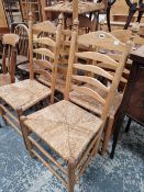 A SET OF RUSH SEAT LADDER BACK CHAIRS.