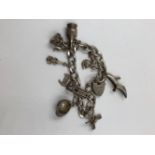 A SILVER VINTAGE CHARM BRACELET COMPLETE WITH PADLOCK, SAFETY CHAIN AND NINE VARIOUS CHARMS TO