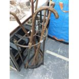 AN EDWARDIAN BRASS AND IRON STICK STAND CONTAINING A HORSE MEASURE WALKING STICK AND FOUR OTHERS.