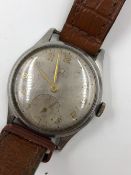 A VINTAGE OMEGA WATCH ON A BROWN LEATHER STRAP.