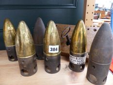 SIX MILITARY MUNITION SHELL HEAD PROJECTILES TOGETHER WITH AN ANTIQUE LOCK AND KEY.