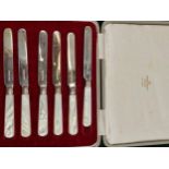 A CASED SET OF HALLMARKED SILVER BLADED BUTTER KNIVES WITH MOTHER OF PEARL HANDLES.