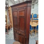 A LARGE GEORGIAN OAK FLOOR STANDING FOUR DOOR CORNER CABINET.