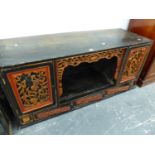 AN ORIENTAL CARVED AND PAINTED LOW SIDE CABINET.