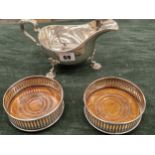 A LARGE HALLMARKED SILVER SAUCE BOAT 333 gms. TOGETHER WITH TWO WOODEN BASED SILVER COASTERS. (3)